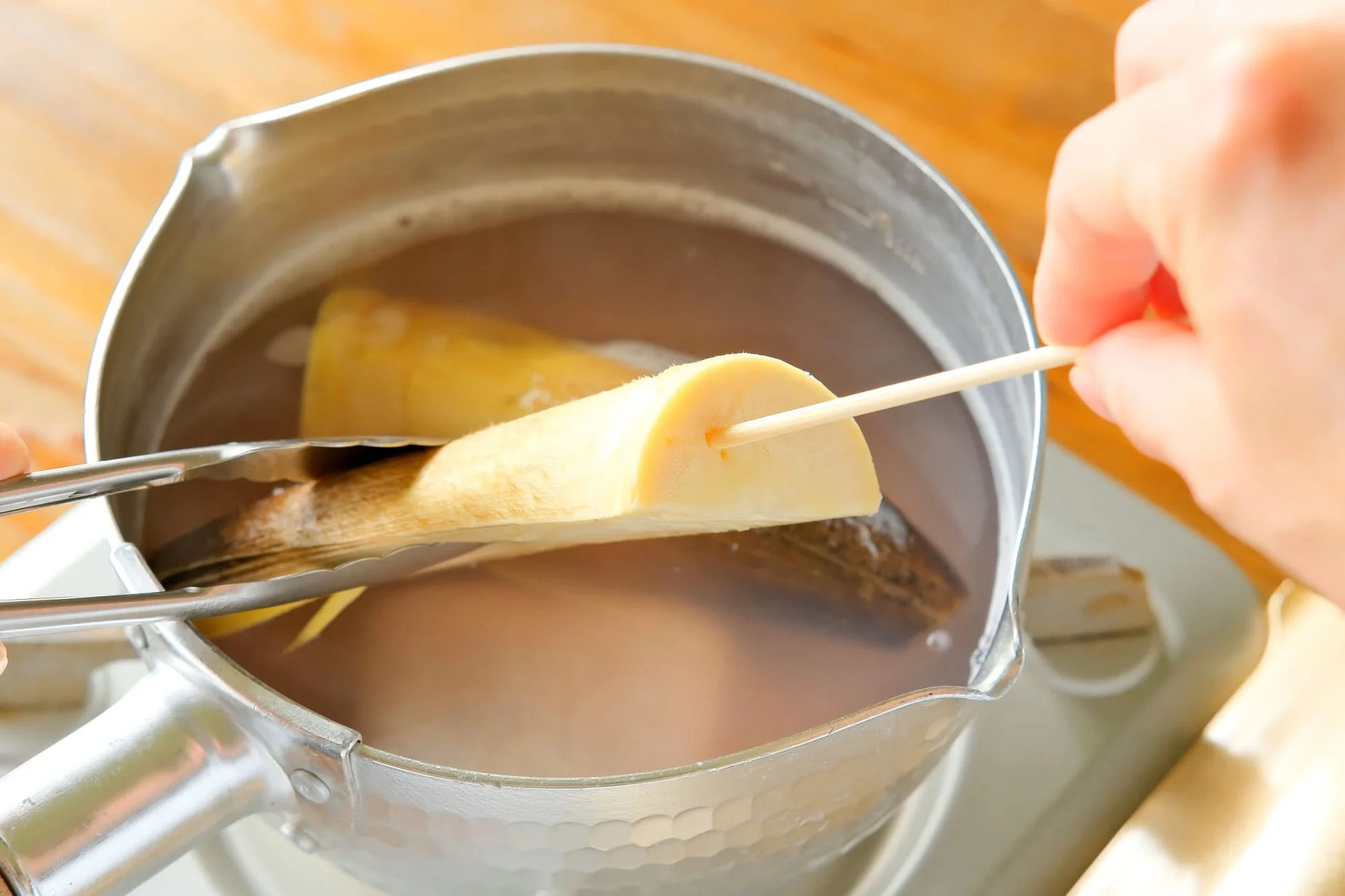鍋でたけのこを茹でて竹串で確認している様子